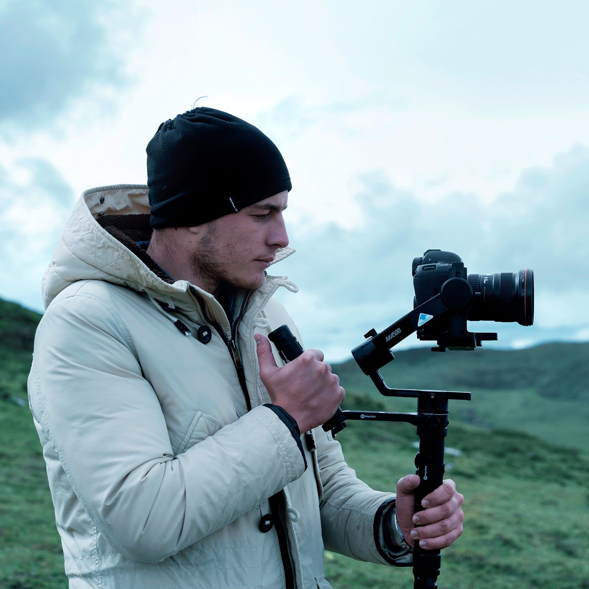 A man holds the remote contro handle and extension rod