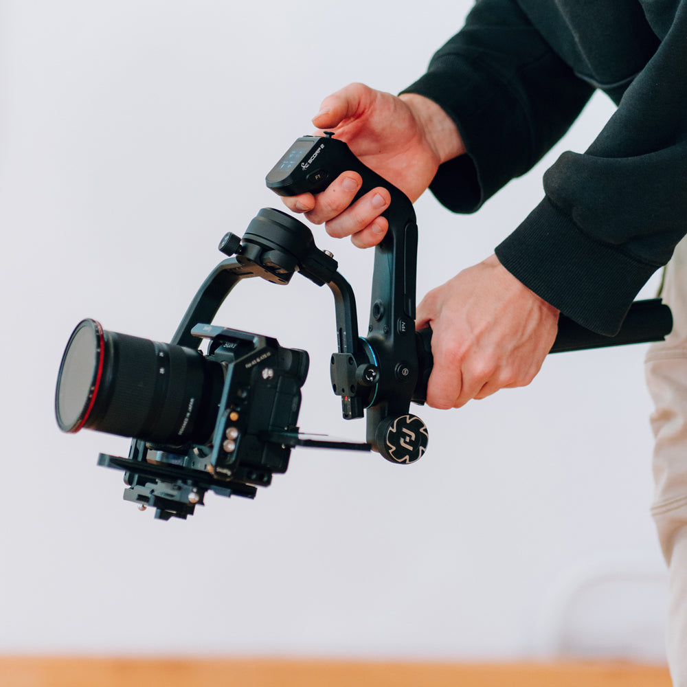 A person holding Scorp 2 camera gimbal for a low angle shot