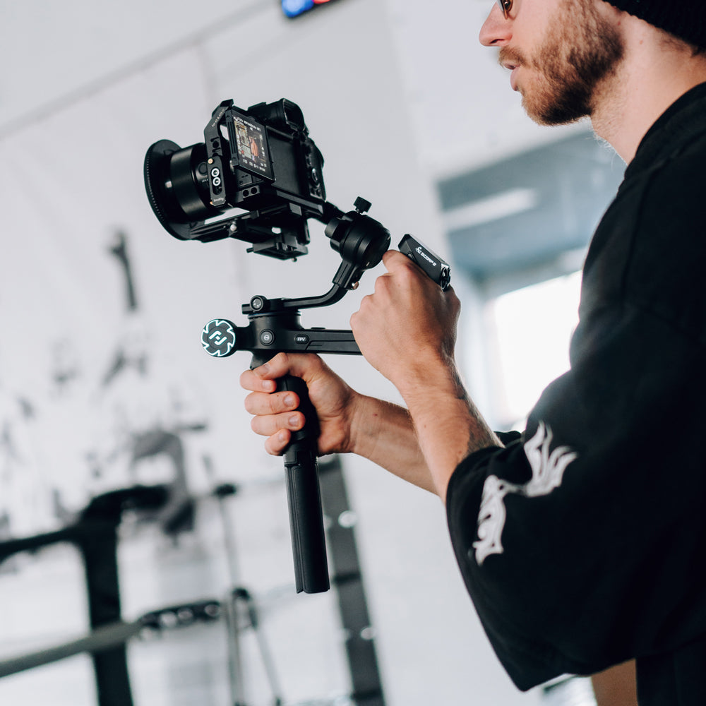 A person holding the Scorp 2 camera gimbal with both hands for a long shot